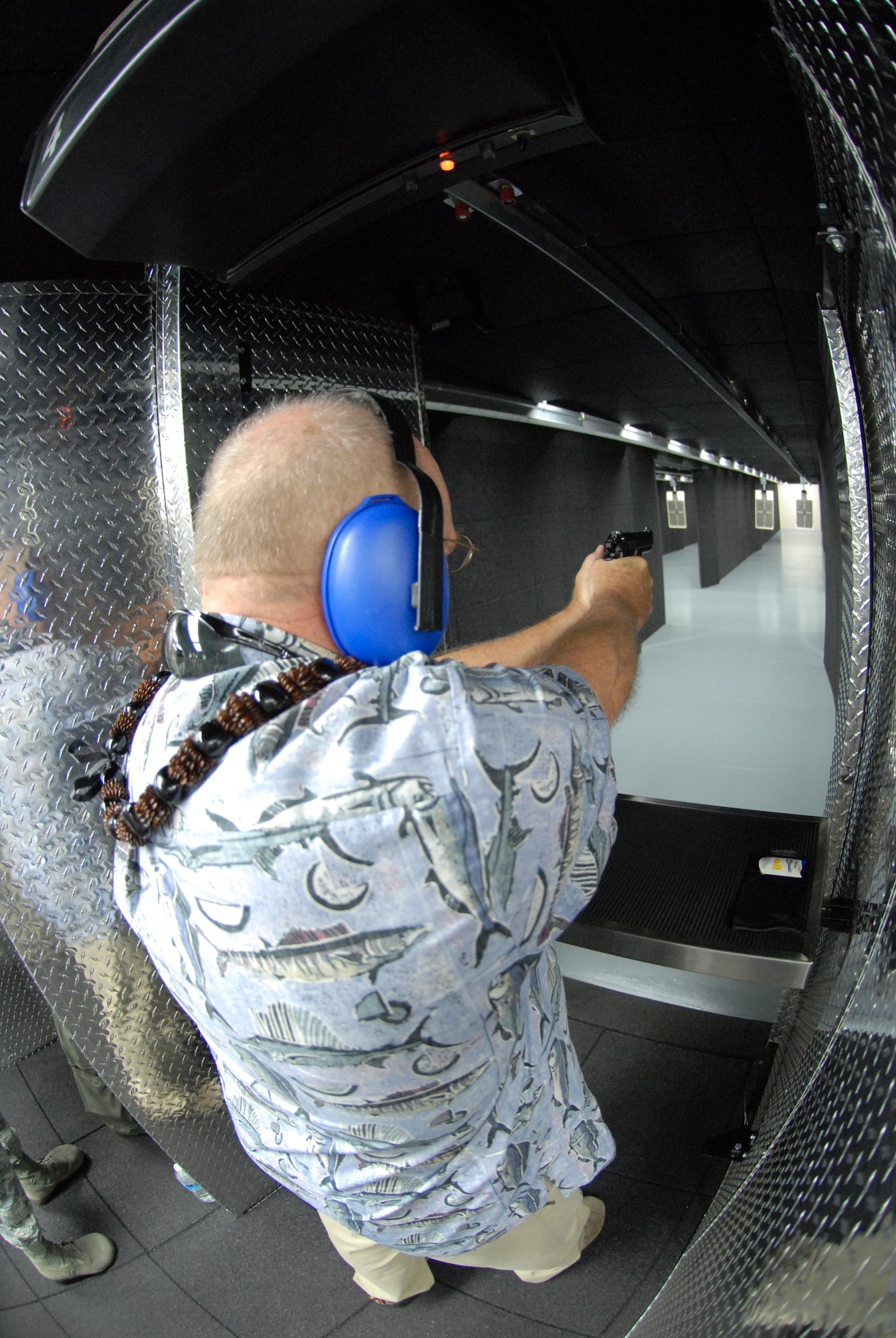 U.S. Air Force Brig. Gen. Stan Osserman (retired), former commander of the Hawaii Air National Guard, aims down range after the blessing of the 154th Security Force Squadron Indoor Firing Range at Joint Base Pearl Harbor-Hickam, Hawaii, Aug. 8, 2015. Osserman played an instrumental part in procuring the range for the Hawaii Air National Guard. The range is one of three deployed throughout the Air National Gaurd nationwide and features virtual simulations as part of the fire arms training. (U.S. Air National Guard photo by Airman 1st Class Robert Cabuco)
