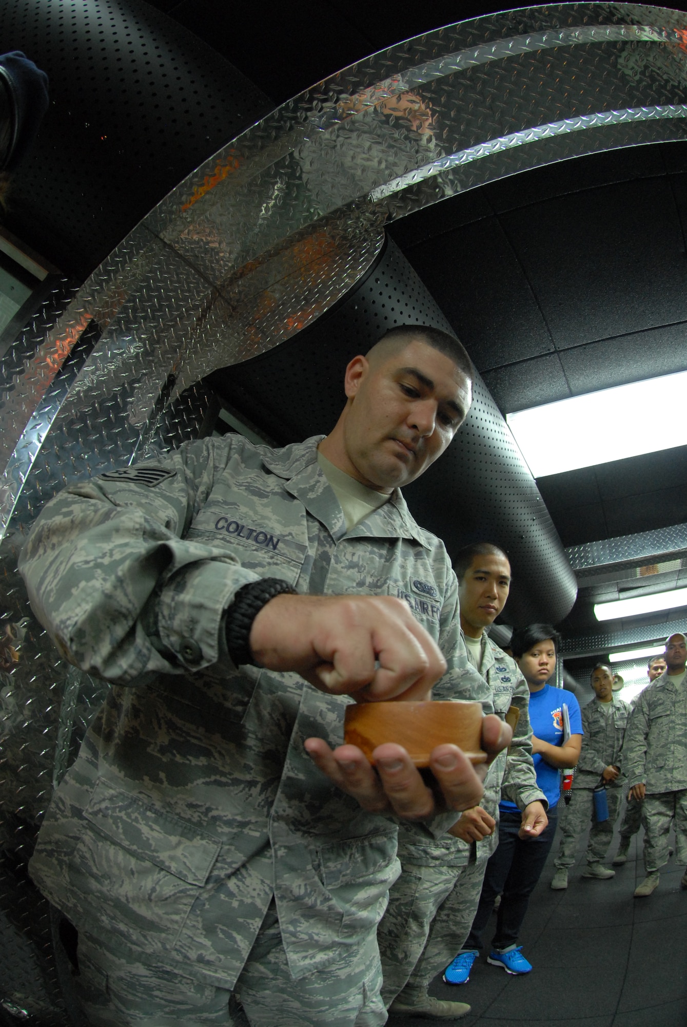 U.S. Air Force Staff Sgt Bronson Colton, 154th Security Forces Squadron (SFS), grabs a pinch of salt during the blessing ceremony of the 154th SFS Indoor Firing Range at Joint Base Pearl Harbor-Hickam, Hawaii, Aug. 8, 2015. Salt is spread throughout the facility by the Chaplain and members of the 154th SFS as a way to purify and protect the facility. (U.S. Air National Guard photo by Airman 1st Class Robert Cabuco)
