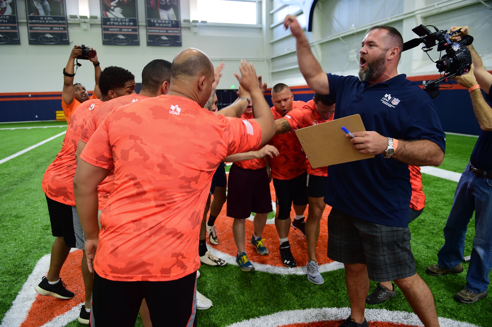 A former Denver Broncos player, assisting with the military combine, gets military members excited before the bench press portion of the combine Aug. 7, 2015, at the Broncos Headquarters Facility at Dove Valley in Denver. The combine consisted of drills similar to the ones prospective National Football League players are expected to complete during the NFL combine held in Indianapolis before the NFL draft. All participants were also treated to a viewing of the Broncos’ Friday morning practice and a visit from Broncos players, as well as the head coach. (U.S. Air Force photo by Airman 1st Class Luke W. Nowakowski/Released)