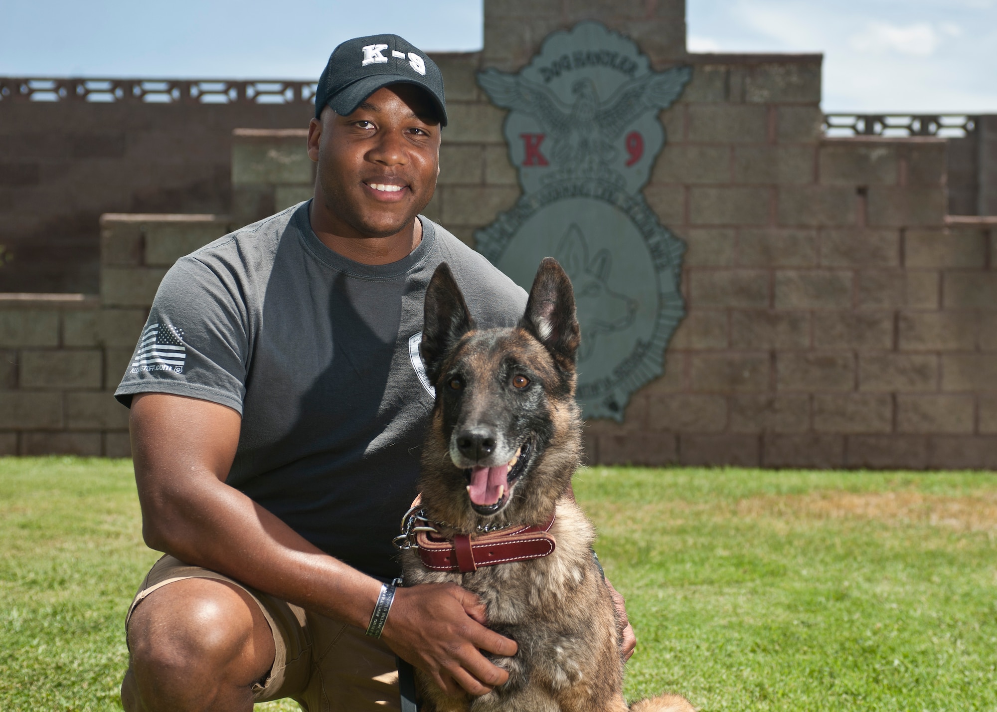 Staff Sgt. Mark Bush, 28th Security Forces Squadron military working dog handler, poses with his retired MWD, Chukky, at Nellis Air Force Base, Nev., July 10, 2015. Bush adopted his furry friend after two deployments and three and a half years together. (U.S. Air Force photo by Staff Sgt. Suita Ika/Released)