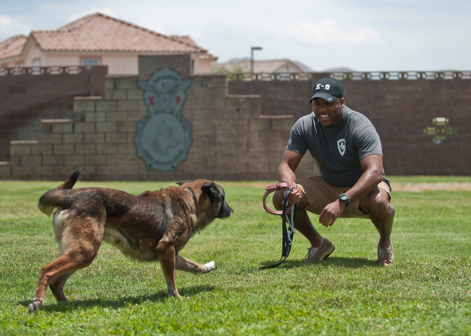 Staff Sgt. Mark Bush, 28th Security Forces Squadron military working dog handler, plays with his retired MWD, Chukky, at Nellis Air Force Base, Nev., July 10, 2015. Chukky retired at Nellis July 10 after serving eight years in the Air Force. (U.S. Air Force photo by Staff Sgt. Suita Ika/Released)
