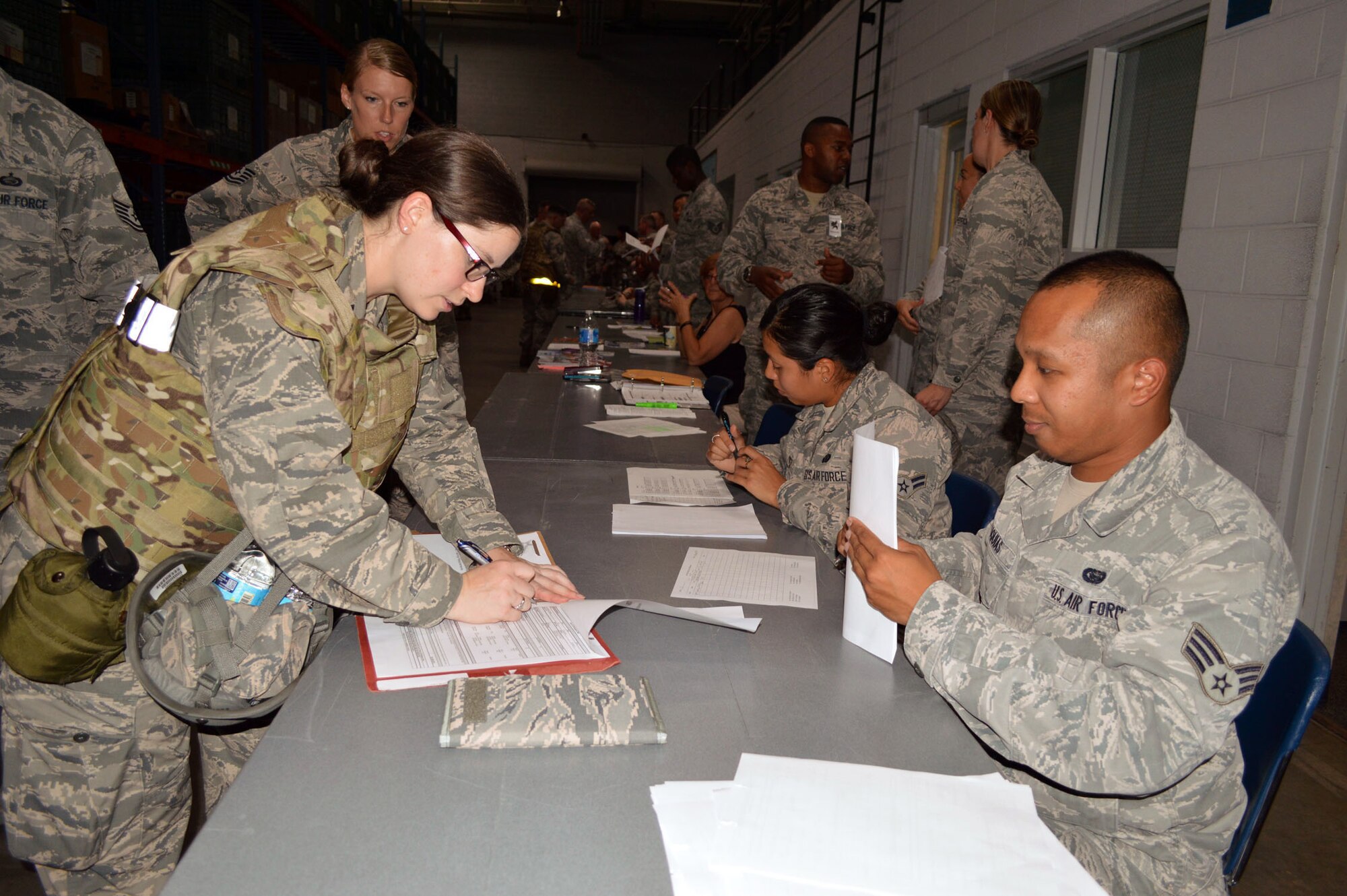 Senior Airman Norman Luquias, right, military personnel specialist assigned to the 43rd Air Base Squadron, checks the eligibility of Capt. Sara Rathgerber, troop commander from the 43rd Airlift Group, tasked to deploy during an operational readiness exercise Aug. 4 at Pope Army Airfield, North Carolina. (U.S. Air Force photo/Marvin Krause)