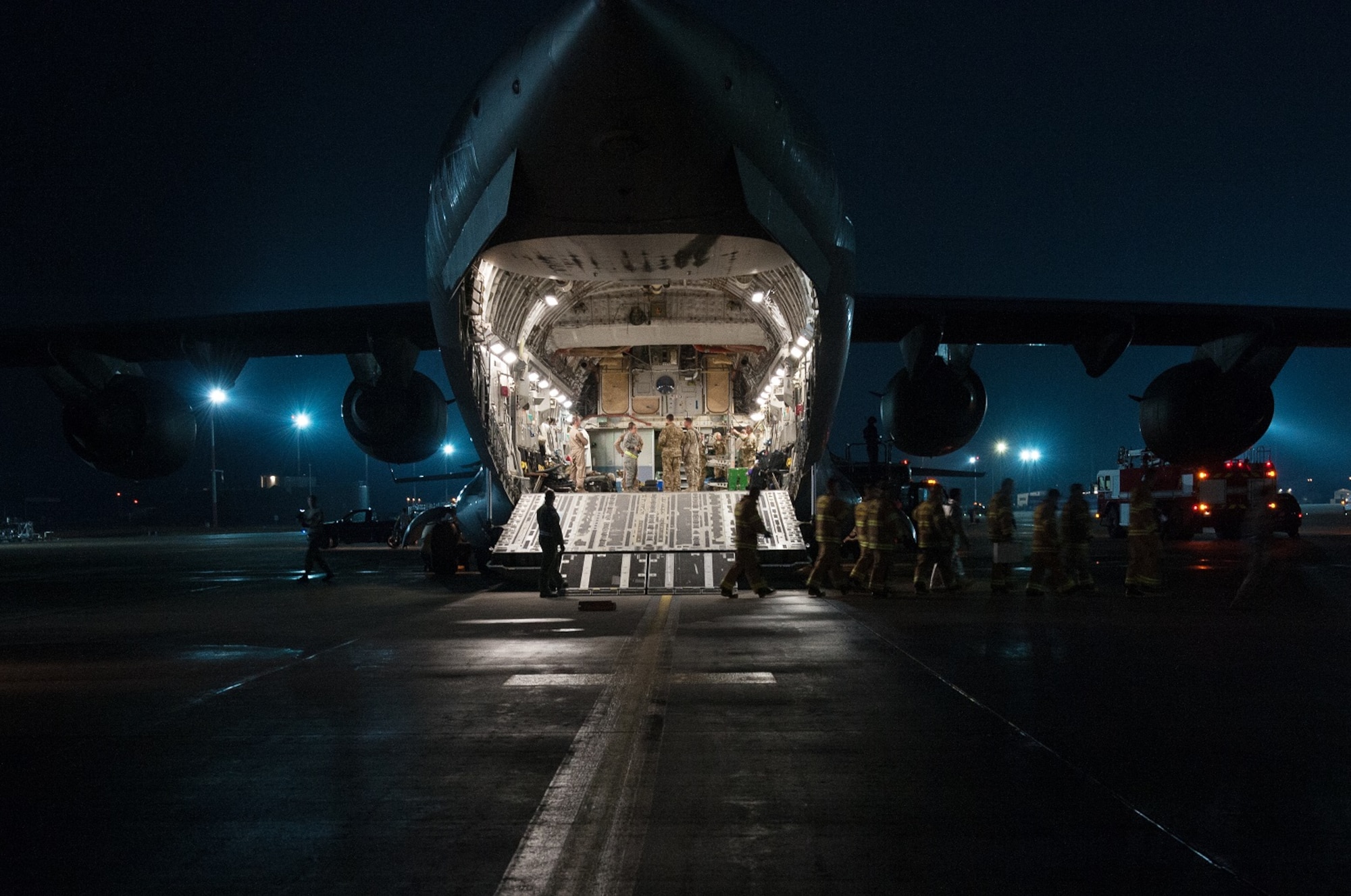 Firefighters from the 86th Civil Engineer Squadron Kaiserslautern Military Community Fire Emergency Services depart a C-17 Globemaster III after assisting in transporting patients from an aeromedical evacuation mission on August 9, 2015 at Ramstein Air Base, Germany. The team of firefighters helped to transport medical patients after they arrived to Ramstein from a several hour flight from Afghanistan. (U.S. Air Force photo/Staff Sgt. Leslie Keopka) 