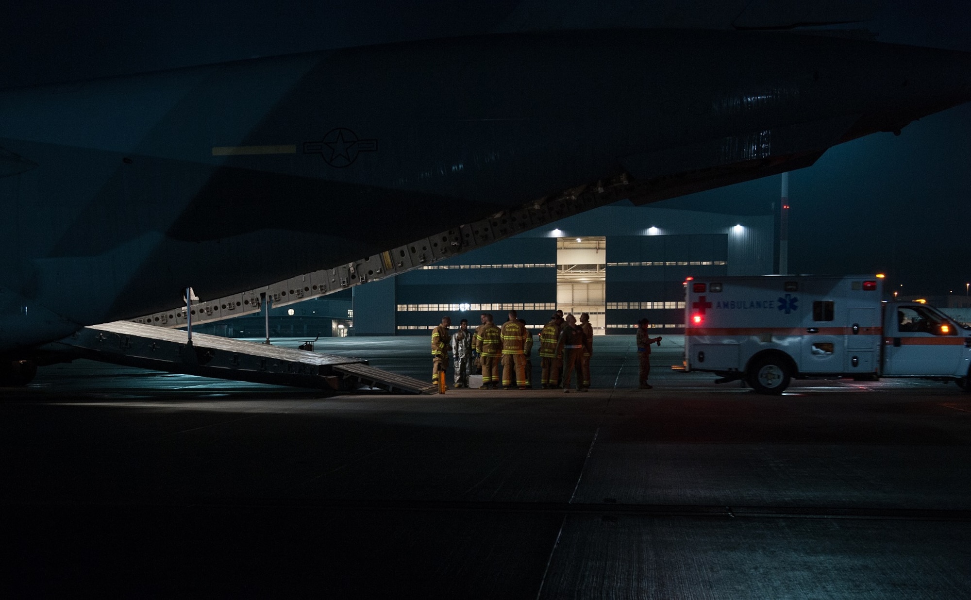 Firefighters from the 86th Civil Engineer Squadron Kaiserslautern Military Community Fire Emergency Services stand by after transporting a wounded warrior from a C-17 Globemaster III to an ambulance on August 9, 2015 on Ramstein Air Base, Germany. Ramstein fire and medical personnel from the 10th Aeromedical Evacuation Operations Team and the 455th Critical Care Air Transport Team assisted with the aeromedical evacuation out of Afghanistan. (U.S. Air Force photo/Staff Sgt. Leslie Keopka)  