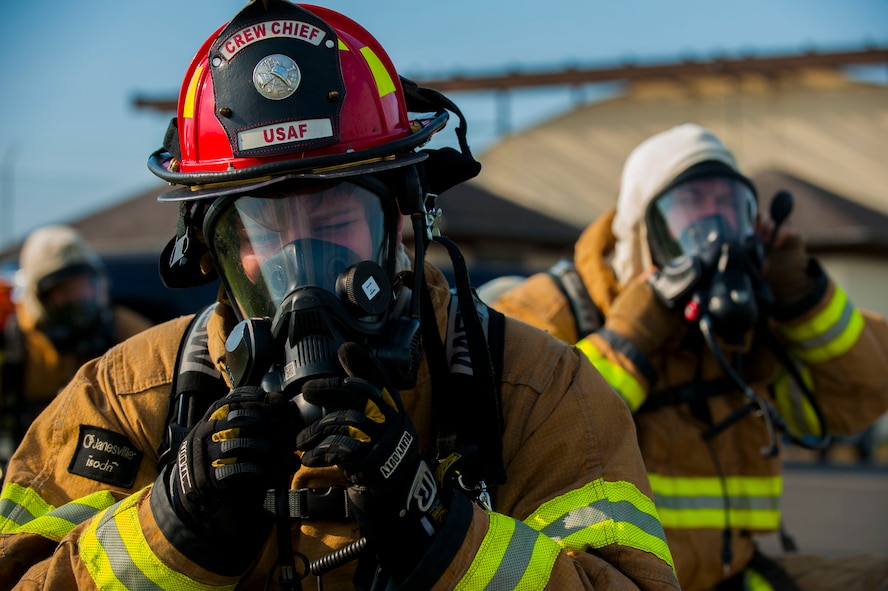 Firefighters from the 52nd Civil Engineer Squadron gear up during a fuel spill exercise on Spangdahlem Air Base, Germany, August 7, 2015. Parties involved in the simulation to attended required training and briefings the day before to prepare on the actions needed for the simulation. (U.S. Air Force photo by Airman 1st Class Timothy Kim/Released)