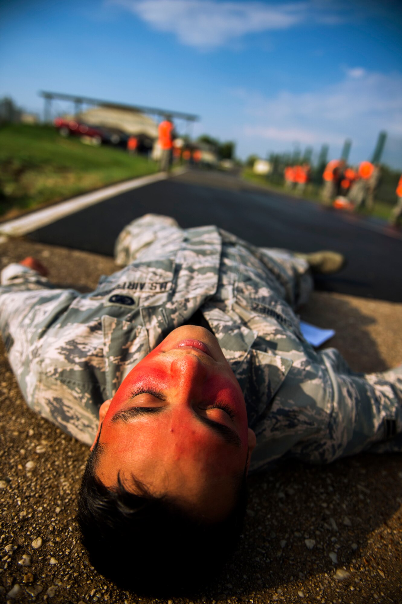 U.S. Air Force Airman 1st Class Humberto Chairez, a 52nd Logistics Readiness Squadron fuels distribution operator and simulated exercise casualty, lies on the floor to simulate an injured casualty during a fuel spill exercise on Spangdahlem Air Base, Germany, August 7, 2015. The exercise required teams from the 52nd Fighter Wing staff agencies, 52nd Security Forces Squadron, 52nd Civil Engineer Squadron and the 52nd Logistics Readiness Squadron to respond to the simulation. (U.S. Air Force photo by Airman 1st Class Timothy Kim/Released)