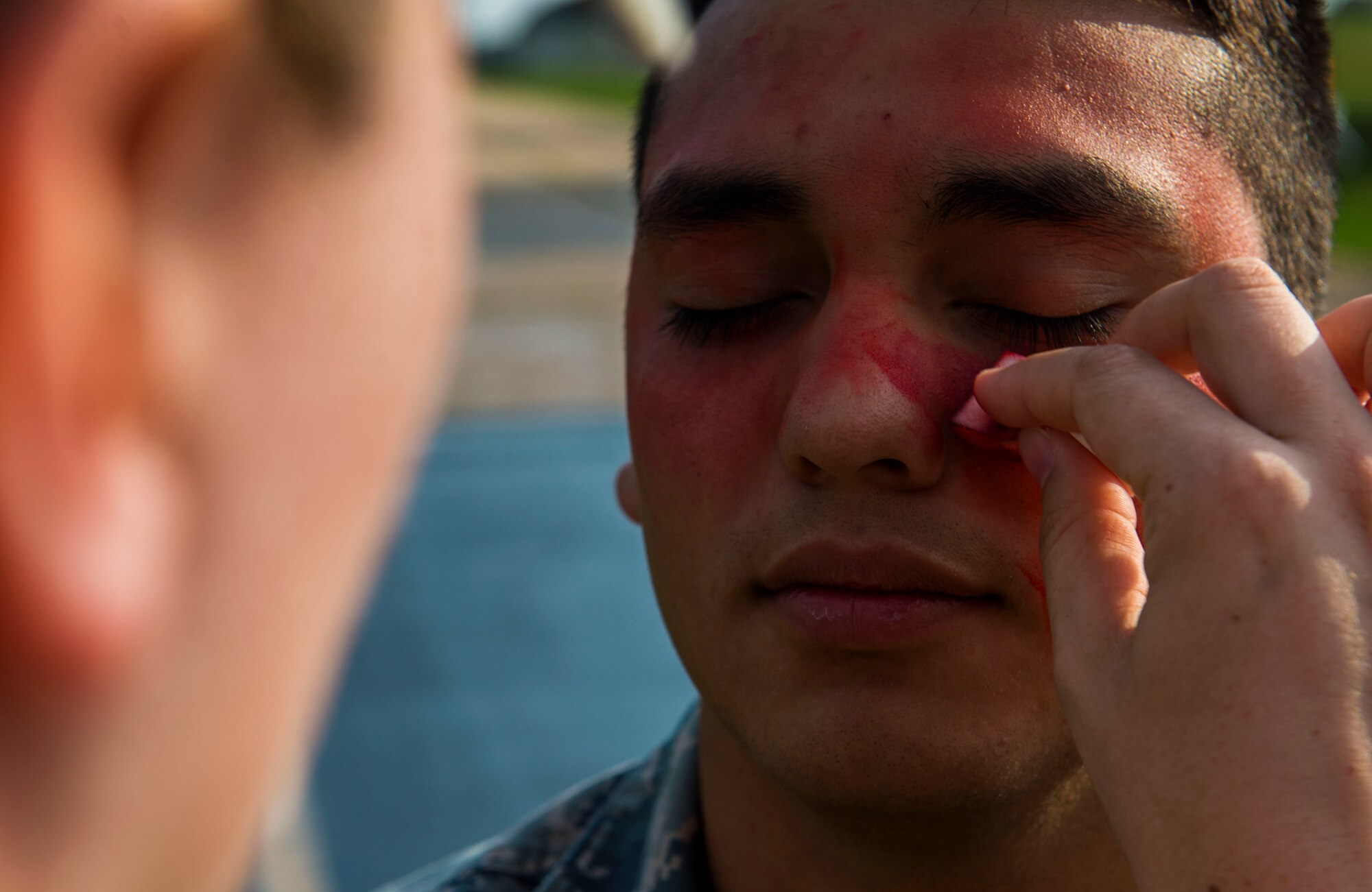U.S. Air Force Airman 1st Class Humberto Chairez, a 52nd Logistics Readiness Squadron fuels distribution operator and simulated exercise casualty, receives make up to simulate burns during a fuel spill exercise on Spangdahlem Air Base, Germany, August 7, 2015. The exercise assessed the ability of the 52nd Fighter Wing to respond to a large-scale fuel spill. (U.S. Air Force photo by Airman 1st Class Timothy Kim/Released)