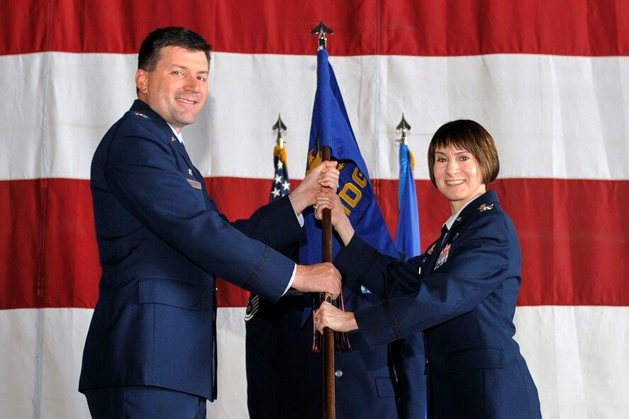 U.S. Air Force Col. Jill Scheckel takes the 55th Medical Group guidon from U.S. Air Force Col. Marty Reynolds, 55th Wing commander, during a change of command ceremony at the Bennie Davis Maintenance Facility on Offutt Air Force Base, Nebraska, Aug. 7. Scheckel took command of the mighty medics from U.S. Air Force Col. Stephen Mounts during the time honored ceremony. (U.S. Air Force photo by Jeff Gates)