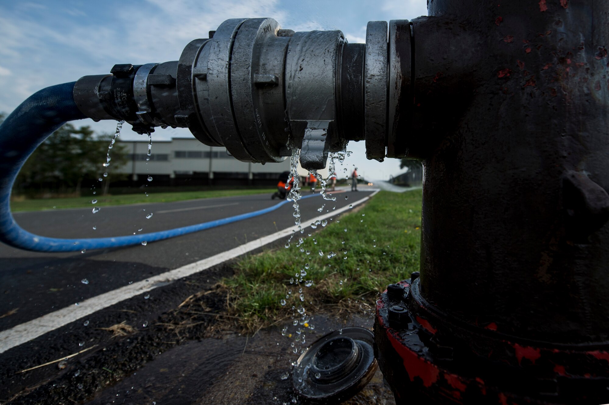 Water drips from a fire hydrant as members of the exercise evaluation team spray water on the ground, prior to the start of an exercise Aug. 7, 2015, at Spangdahlem Air Base, Germany. The water simulated over 40,000 gallons of fuel spilt during the exercise. (U.S. Air Force photo by Senior Airman Rusty Frank/Released)