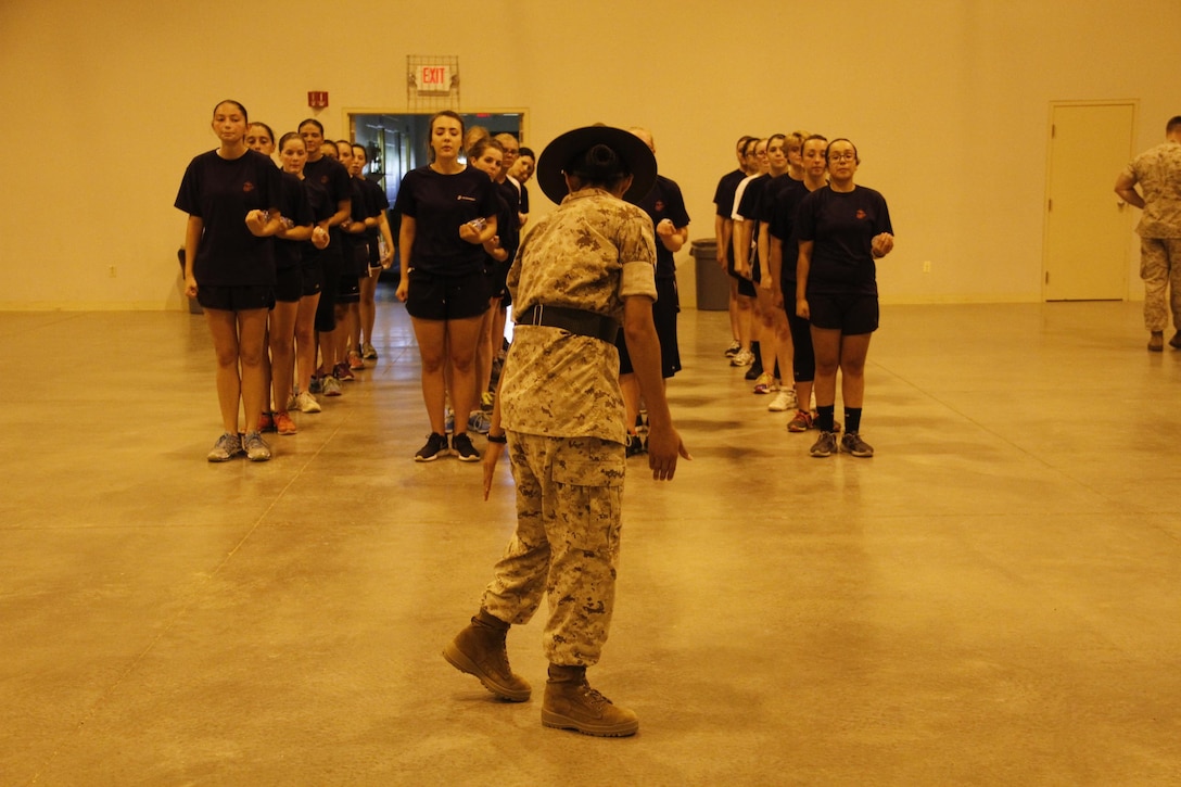 Sergeant Rosario Battiest, a Company N, 4th Recruit Training Battalion, Marine Corps Recruit Depot Parris Island drill instructor, demonstrates proper drill techniques during Marine Corps Recruiting Station Kansas City's all-hands female pool function at Camp Clark in Nevada, Mo., Aug. 7, 2015.