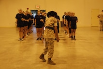 Sergeant Rosario Battiest, a Company N, 4th Recruit Training Battalion, Marine Corps Recruit Depot Parris Island drill instructor, demonstrates proper drill techniques during Marine Corps Recruiting Station Kansas City's all-hands female pool function at Camp Clark in Nevada, Mo., Aug. 7, 2015.