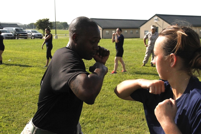 Staff Sergeant Norris L. Russell Jr., a Marine Corps Recruiting Station Kansas City recruiter, demonstrates a proper horizontal elbow strike to a poolee during RS Kansas City's all-hands female pool function at Camp Clark in Nevada, Mo., Aug. 7, 2015. 