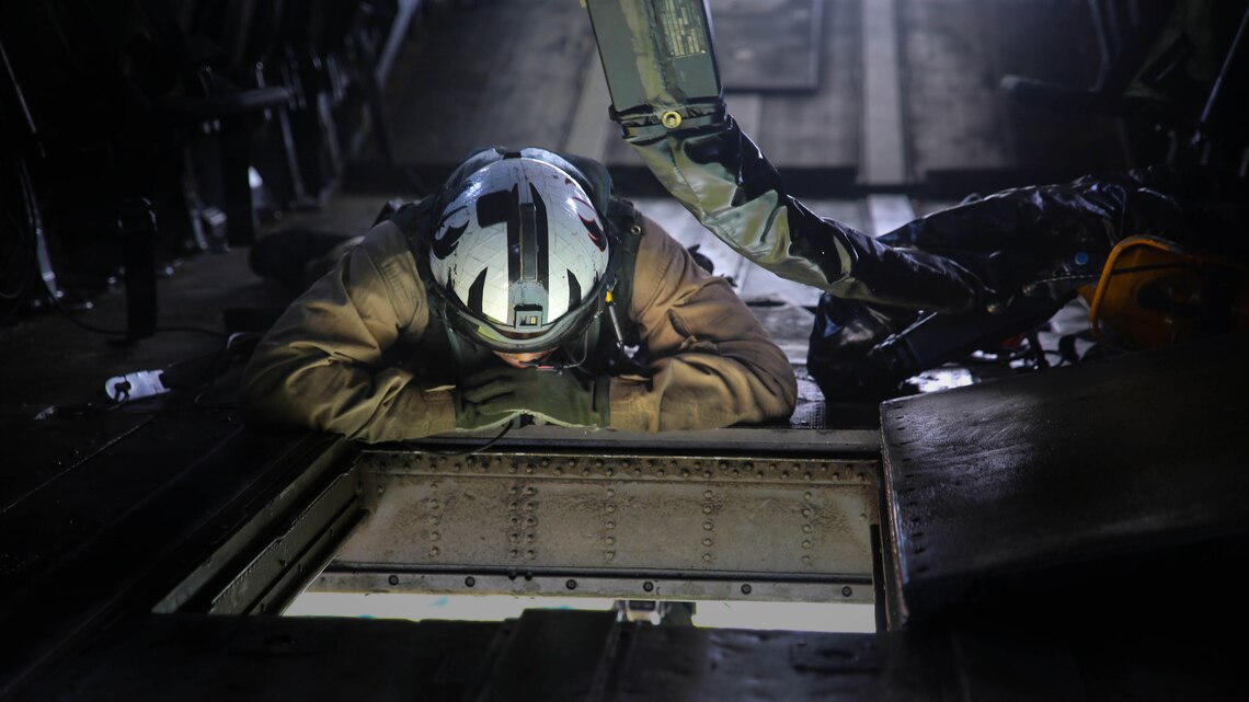 A Marine onboard a CH-53E Super Stallion with Marine Heavy Helicopter Training Squadron 302 directs movement during an external lift exercise with Combat Logistics Battalion 6 at Marine Corps Base Camp Lejeune, North Carolina, Aug. 5, 2015. Two student pilots onboard the helicopter performed external lifts for the first time, an operation essential to deployed operations, and part of their pilot certification. 