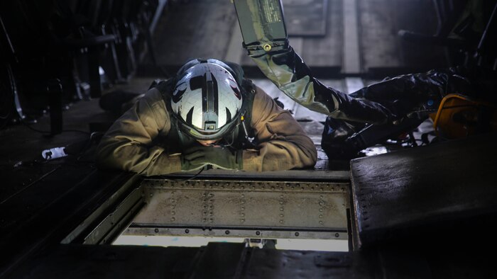A Marine onboard a CH-53E Super Stallion with Marine Heavy Helicopter Training Squadron 302 directs movement during an external lift exercise with Combat Logistics Battalion 6 at Marine Corps Base Camp Lejeune, North Carolina, Aug. 5, 2015. Two student pilots onboard the helicopter performed external lifts for the first time, an operation essential to deployed operations, and part of their pilot certification. 