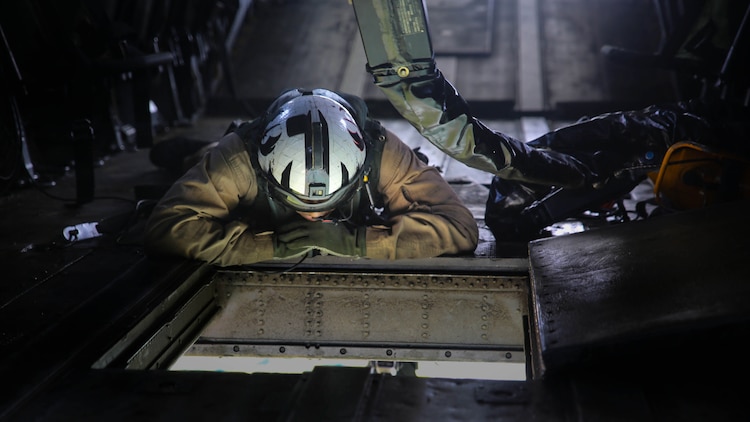 A Marine onboard a CH-53E Super Stallion with Marine Heavy Helicopter Training Squadron 302 directs movement during an external lift exercise with Combat Logistics Battalion 6 at Marine Corps Base Camp Lejeune, North Carolina, Aug. 5, 2015. Two student pilots onboard the helicopter performed external lifts for the first time, an operation essential to deployed operations, and part of their pilot certification. 