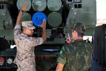 Master Sgt. Alex Ng, the field artillery chief assigned to Battery Q, 5th Battalion, 11th Marine Regiment, 1st Marine Division, explains the abilities of the M142 High-Mobility Artillery Rocket System to Maj. Rafael Pires Ferreira, a battery commander with Brazil’s Corpo de Fuzileios, aboard Marine Corps Base Camp Pendleton, Calif., Aug. 5, 2015. Two Brazilian military officers participated in a Subject Matter Expert Exchange with the Marines and Sailors of 11th Marines to compare standard operating procedures and to share experiences and ideas.