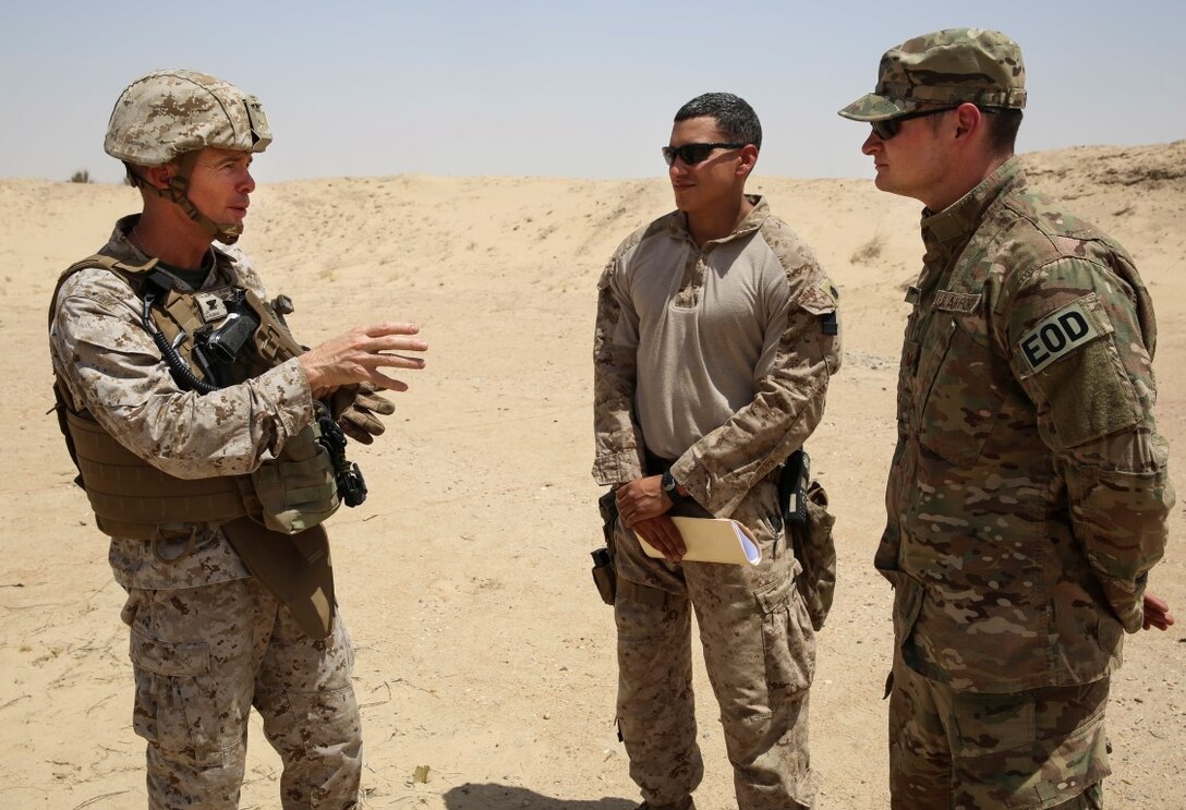 U.S. Marine Col. Jay Bargeron, commanding officer of Special Purpose Marine Air-Ground Task Force—Crisis Response—Central Command, speaks with Staff Sgt. Joshua Martinez and Tech. Sgt. Johnathan Finn, explosive ordnance technicians, during a demolition range in Southwest Asia, July 17, 2015. The Marines and Sailors of SPMAGTF-CR-CC provide the commander of USCENTCOM with a flexible, task-organized set of solutions to emerging crises within an area of responsibility spanning 20 countries. (U.S. Marine Corps Photo by Cpl Leah Agler/RELEASED)