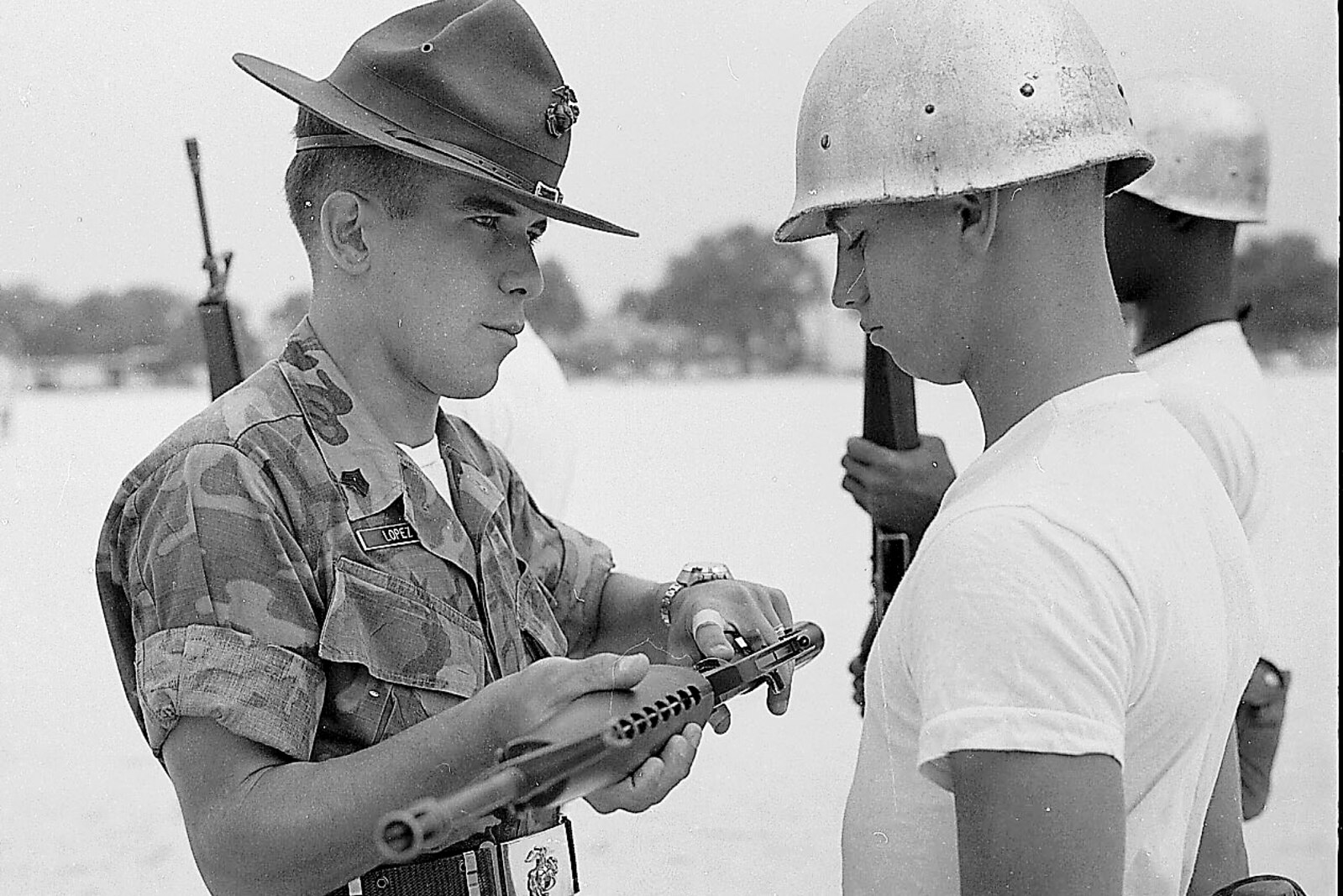 A drill instructor inspects a recruit's rifle in this early-1980's era photo.