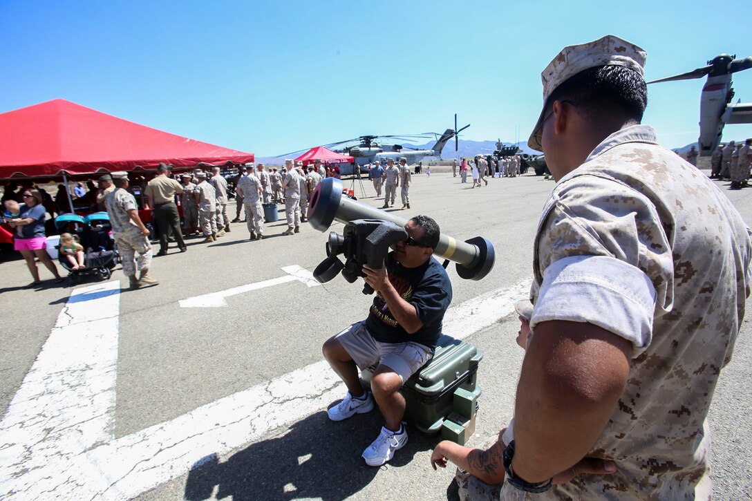 A Marine with the 13th Marine Expeditionary Unit allows a curious family member to use an anti-air javelin system aboard Marine Corps Base Camp Pendleton, Calif., August 7, 2015. The 13th MEU held their Composite Ceremony today, followed by a Family Day to signify unity of the newly composited Marine Air-Ground Task Force.
