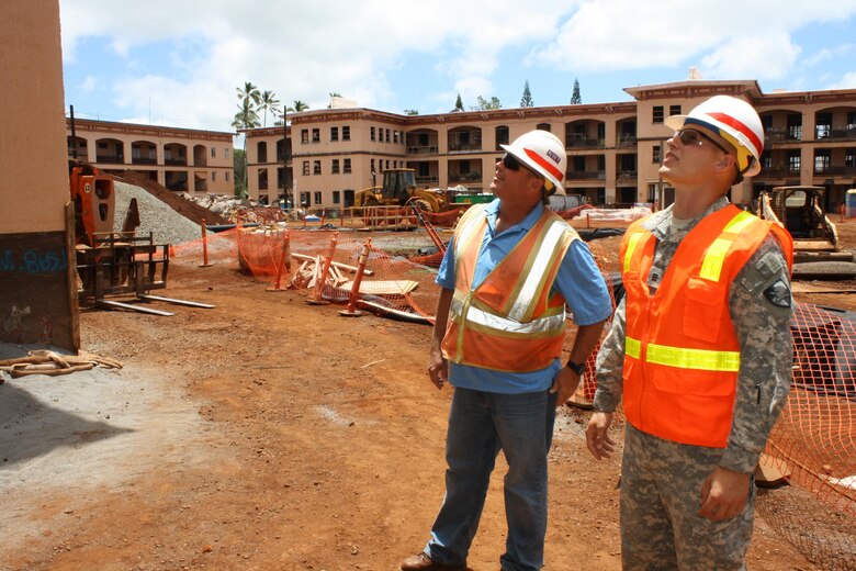 Cadet Calvin Kiesewetter (right) and Army Corps of Engineers Construction Control Representative Joe Tribbey look at a building window frame at the Corps’ Quad B renovation project site. 