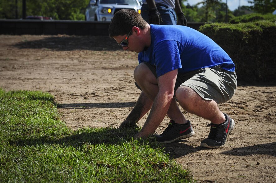 Senior Airman Brice Evans, 1st Special Operations Maintenance Group aircraft scheduler, places sod at Soundside Lodging on Hurlburt Field, Fla., Aug. 6, 2015. Approximately 30 Airmen from Hurlburt laid 19,800 square feet of sod at Soundside Lodging as part of Pride Epidemic. (U.S. Air Force photo by Senior Airman Meagan Schutter)