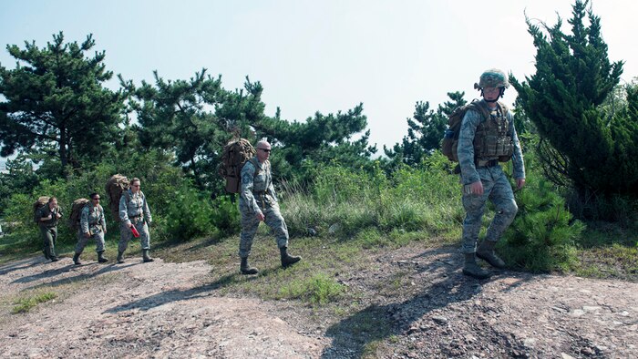 KUNSAN AIR BASE, Republic of Korea (Aug. 6, 2015) - Staff Sgt. Matthew Edge, 8th Civil Engineer Squadron explosive ordnance disposal technician (right), searches the ground for an improvised explosive device as Chief Master Sgt. David "Falcon Chief" Abell, 8th Mission Support Group superintendent, and Lt. Col. Aimee "Falcon II" Alvstad, 8th MSG deputy commander, provide security during combat EOD training.  Alvstad and Abell witnessed the detection, identification, recovery and disposal of a simulated IED during a training operation conducted by U.S. Air Force explosive ordnance disposal technicians of the 8th CES as part of their hands-on immersion to the Wolf Pack. 