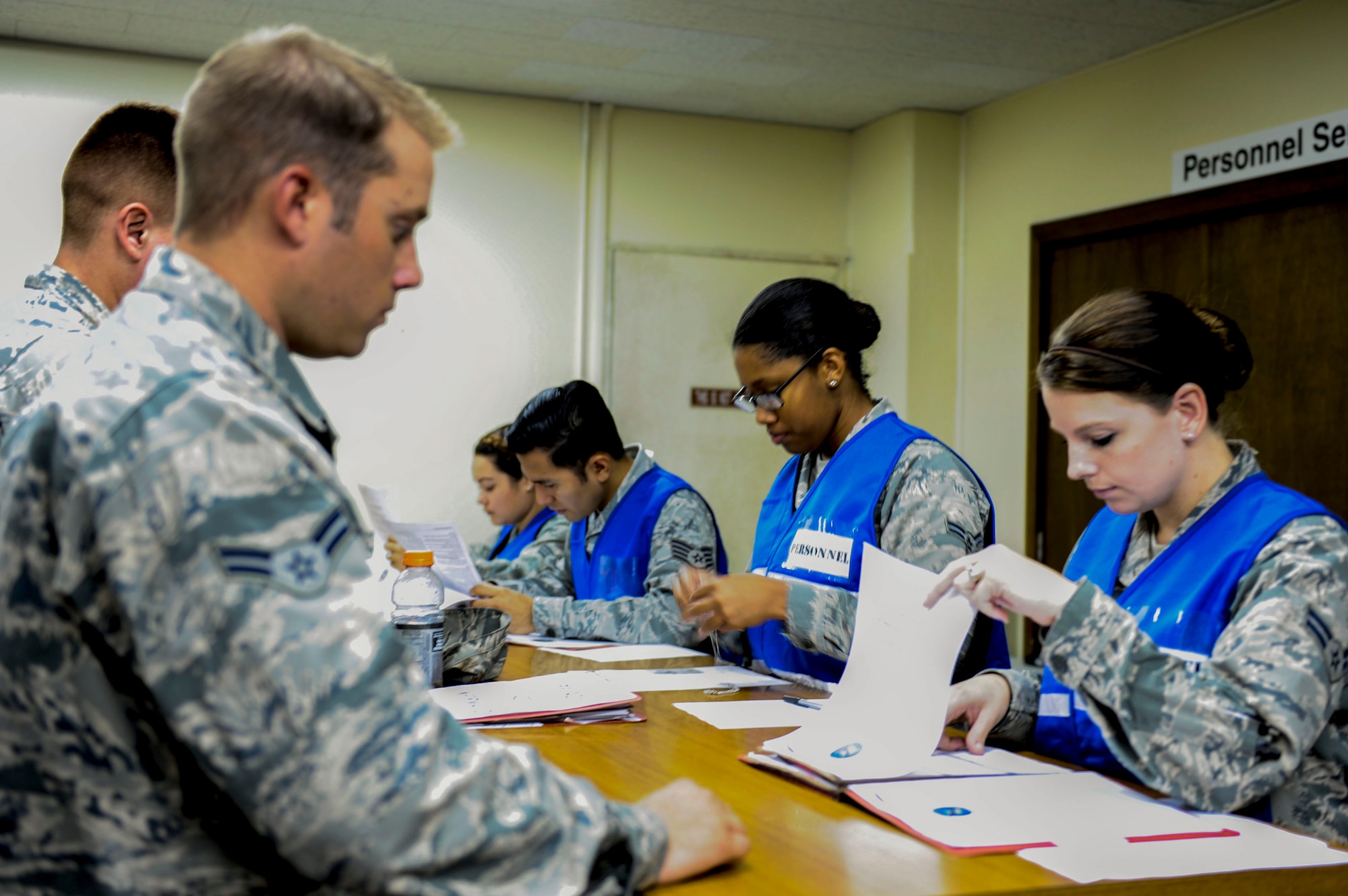 U.S. Air Force Airmen wait in line to have their documents processed by personnel during a Mission-Focused Exercise on Kadena Air Base, Japan, Aug. 4, 2015. The exercise focused on testing Kadena’s ability to deploy forces and cargo in a moment’s notice. (U.S. Air Force photo by Airman 1st Class Lynette Rolen)