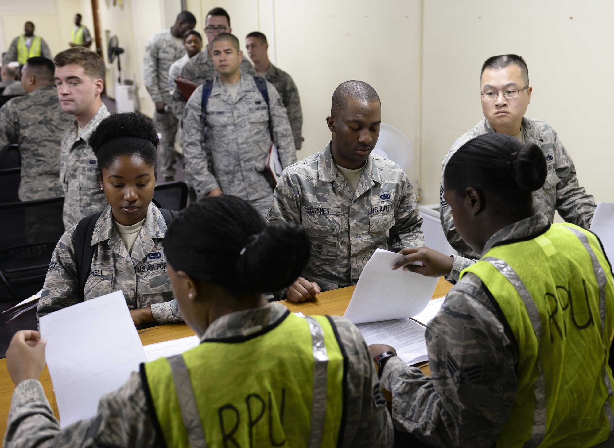 U.S. Air Force Airmen go through a reception processing unit as part of a Mission Focused Exercise on Kadena Air Base, Japan, Aug. 5, 2015. Representatives from various base agencies provided booths for mock-deployers in order to quickly and effectively prepare them for their simulated assignments. MFEs are designed to simulate contingency operations taken from one or more of the wing's mission sets such as forward power projection with the purpose of polishing procedures and demonstrating capabilities. (U.S. Air Force photo by Airman 1st Class John Linzmeier)