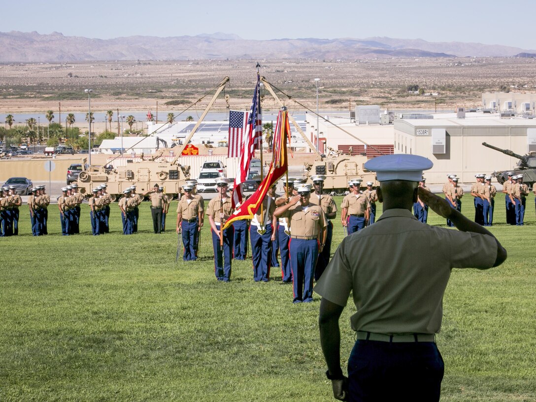 Marines salute during the playing of the National Anthem at a retirement ceremony for 1st Sgt. Nelson A. Hidalgo, Company A First Sergeant, 1st Tanks, at Lance Cpl. Torrey L. Gray Field, Aug. 7, 2015. Hidalgo retired after 20 years of service in the Marine Corps. (Official Marine Corps photo by Pfc. Levi Schultz/Released)