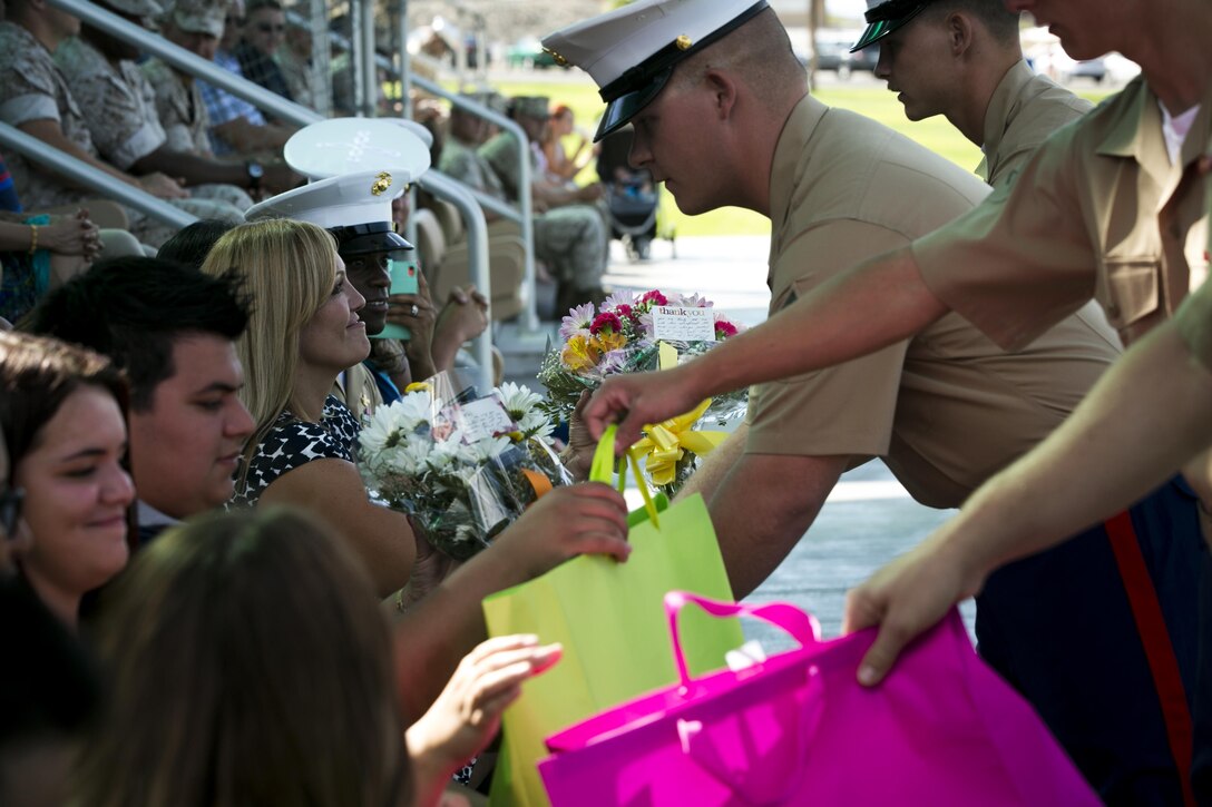Marines with 1st Tank Battalion give flowers and gifts as thanks to the family of 1st Sgt. Nelson A. Hidalgo, Company A First Sergeant, 1st Tanks, during his retirement ceremony at Lance Cpl. Torrey L. Gray Field, Aug. 7, 2015. Following his retirement, Hidalgo intends to shift his focus from his career to taking care of his family. (Official Marine Corps photo by Pfc. Levi Schultz/Released)