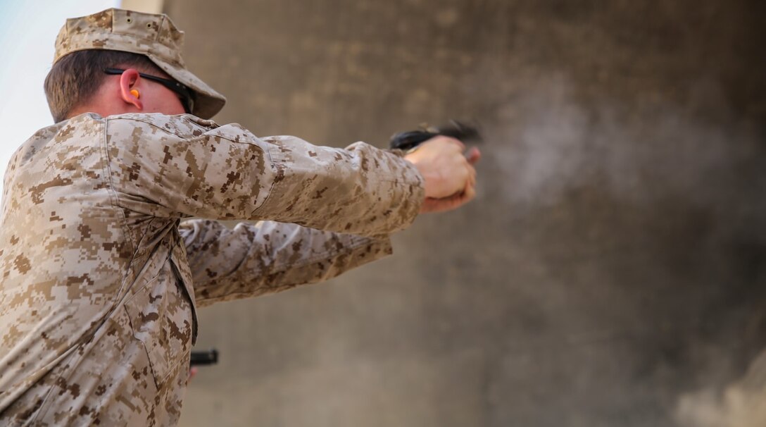 U.S. Marine Lance Cpl. Craig Weston with Special Purpose Marine Air-Ground Task Force - Crisis Response - Central Command fires an M9 pistol during a competitive pistol range while deployed in Southwest Asia, At Sea, July 20, 2015. The Marines and Sailors of SPMAGTF-CR-CC provide the commander of USCENTCOM a nimble set of task-organized solutions to emerging crises in an area of operations spanning 20 countries in the Middle East. 