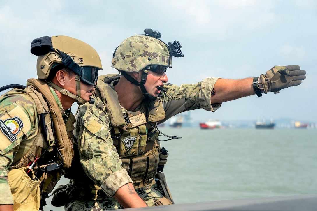 U.S. Navy Petty Officer 1st Class Kevin Diebold, right, communicates with an Indonesian naval special forces team leader while practicing interdiction techniques during Cooperation Afloat Readiness and Training Indonesia 2015 in Surabaya, Indonesia, Aug. 7, 2015. In its 21st year, the annual exercise involves the U.S. Navy, U.S. Marine Corps and the armed forces of nine partner nations. Diebold is assigned to Coastal Riverine Squadron 3. Diebold is a boatswain's mate.