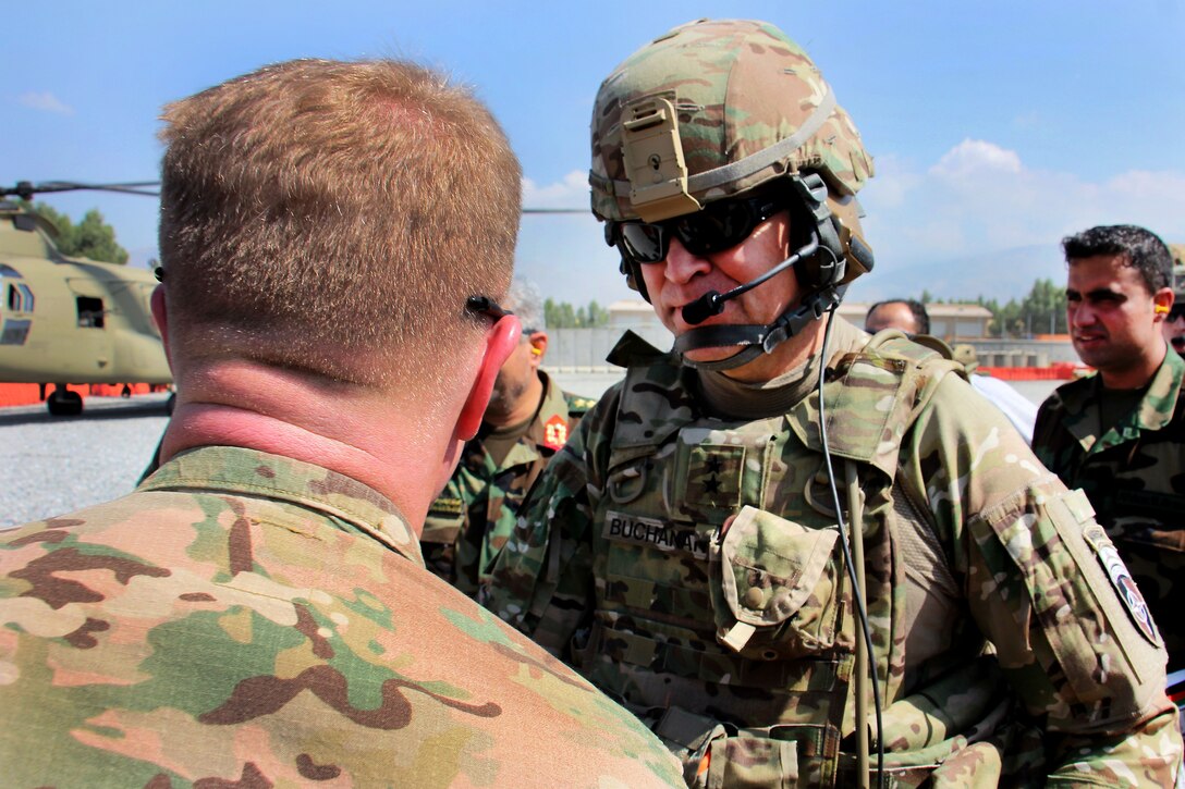 U.S. Army Brig. Gen. Christopher Bentley, left, the commander of Train Advise Assist Command-East, greets U.S. Army Maj. Gen. Jeffrey Buchanan, the Resolute Support deputy chief of staff for operations, upon his arrival to the Regional Military Training Center at Tactical Base Gamberi in Laghman province, Afghanistan, July 30, 2015.