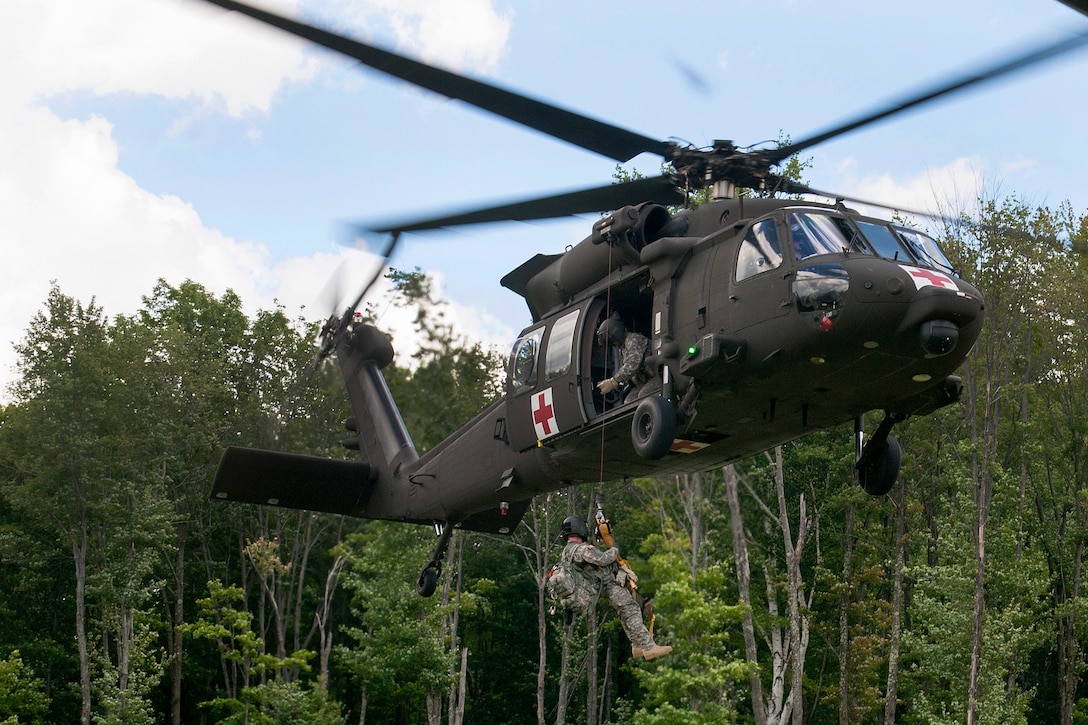 A Vermont Army National Guardsman lowers himself from a UH-60 Black Hawk helicopter on a jungle penetrator during medical evacuation training at Camp Ethan Allen Training Site, Jericho, Vt., Aug. 1, 2015. The soldier is a flight medic assigned to the Vermont Army National Guard's Company C, 3rd Battalion, 126th Aviation Regiment, Air Ambulance.