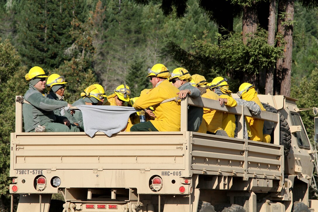 Soldiers depart on tactical vehicles at Eel River Conservation Camp in Redway, Calif., Aug. 9, 2015, to move up the Humboldt mountains for mop-up missions during the Humboldt Lightning Fire.