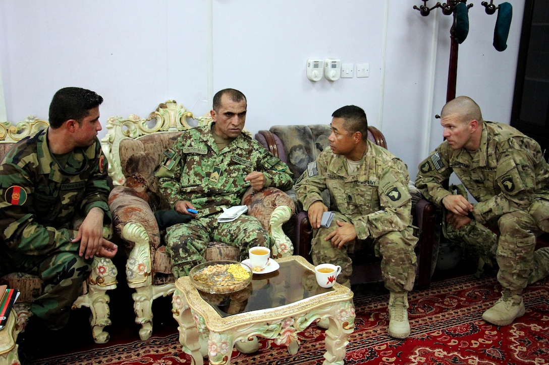 Afghan army Command Sgt. Maj. Roshan Safi, center left, sergeant major of the Afghan army, and U.S. Army Command Sgt. Maj. Walter Tagalicud, center right, the Train Advise Assist Command-East command sergeant major, talk during an office call following the inspection of Afghan soldiers at the Regional Military Training Center at Tactical Base Gamberi in Laghman province, Afghanistan, July 30, 2015.