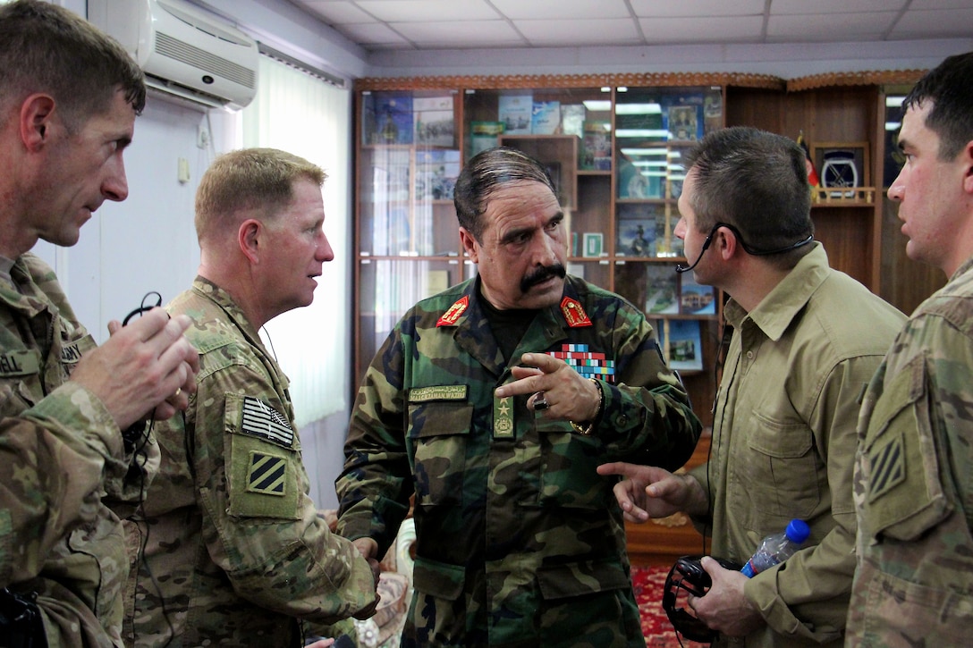 Afghan army Maj. Gen. Mohammad Zaman Waziri, center, 201st Corps commander, talks with U.S. Army Brig. Gen. Christopher Bentley, second from left, commander of Train Advise Assist Command-East, during an office call following the inspection of Afghan soldiers at the Regional Military Training Center at Tactical Base Gamberi in Laghman province, Afghanistan, July 30, 2015.