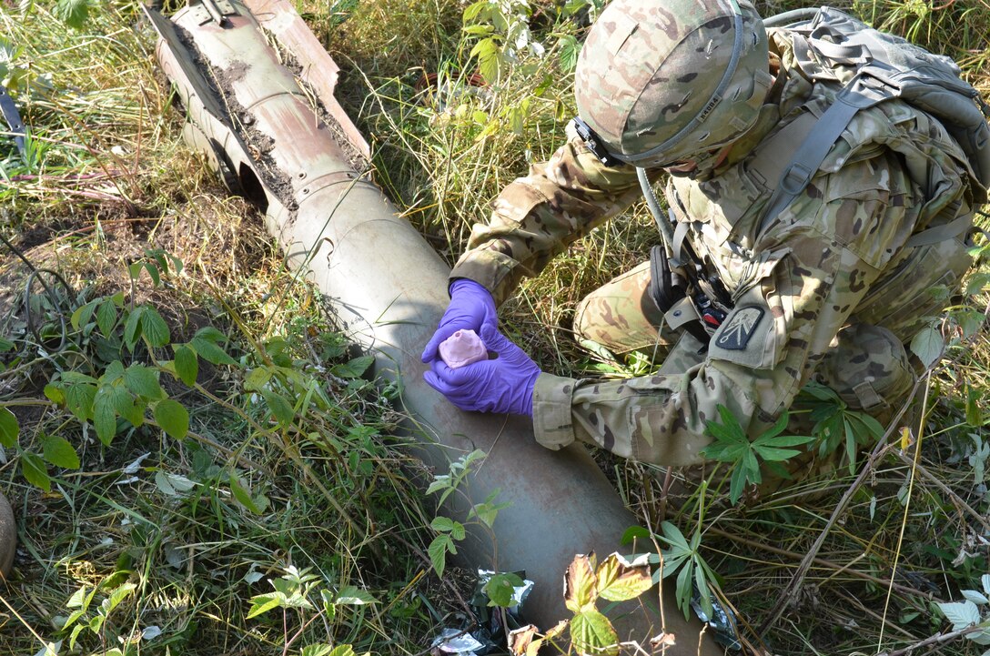 A U.S. soldier assists German forces with detecting and removing unexploded ammunition at the Baumholder Military Training Area in Baumholder, Germany, Aug. 10, 2015.