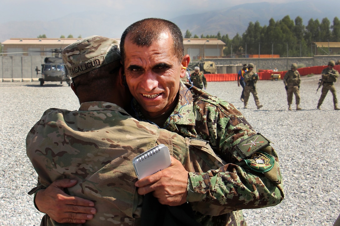 U.S. Army Command Sgt. Maj. Walter Tagalicud, left, the Train Advise Assist Command-East command sergeant major, greets Afghan army Command Sgt. Maj. Roshan Safi, the sergeant major of the Afghan army, during a visit from senior Afghan and Resolute Support leaders to TAAC-E and 201 Corps at Tactical Base Gamberi in Laghman province, Afghanistan, July 30, 2015.