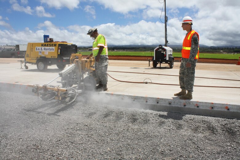 Cadet Walker Glunz (right) observes a contractor using a pole drill on the Combat Aviation Brigade Phase 1 infrastructure project site. 