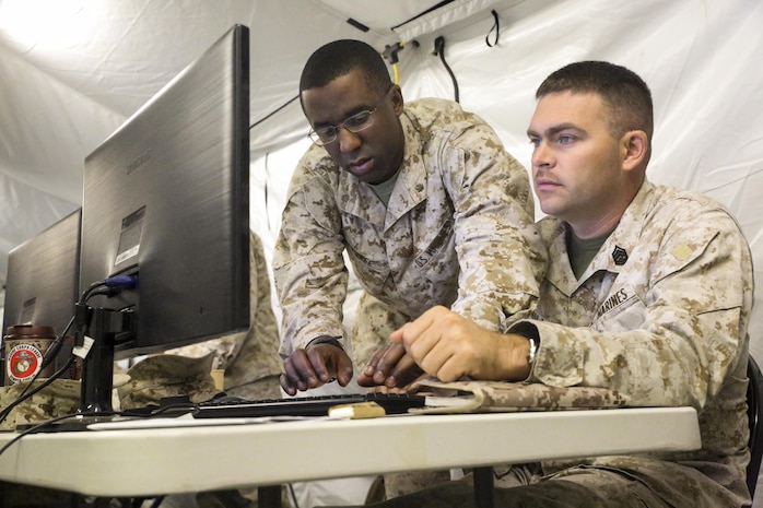 Major William Tyree, the future operations officer with Headquarters Regiment, 2nd Marine Logistics Group, and Gunnery Sgt. Carl Phillips, the future operations chief, review data sent to them from Marines and sailors during a battle skills exercise prior to the start of Large Scale Exercise-15 aboard Marine Corps Air Ground Combat Training Center Twentynine Palms, Calif., Aug. 3-6, 2015.  LSE-15 is a combined U.S. Marine Corps, Canadian and British exercise conducted at the Brigade-level, designed to enable live, virtual and constructive training for participating forces. (U.S. Marine Corps Photo by Cpl. Michael Dye/Released) 
