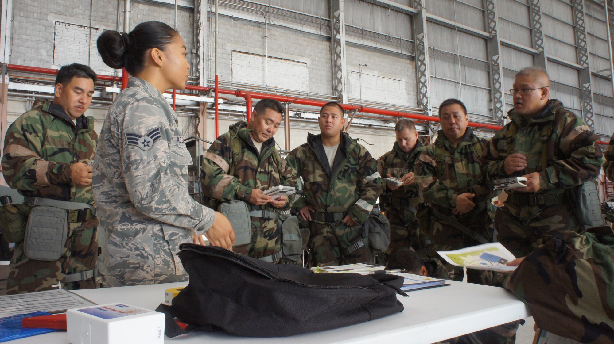 Senior Airman Famellajamie Aquino Chemical Biological and Nuclear Environment survival instructor with the 154th Civil Engineering Squadron walks Hawaii Air National Guard Airmen though a basic map reading exercise during the hands on portion of self-aid and buddy care training during August's unit training assembly, Aug. 9, 2015, Joint Base Pearl Harbor-Hickam. (U.S. Air National Guard Photo by Tech. Sgt. Andrew Jackson)