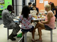 Parents, teachers and students discuss the beginning of the school year during a Back-to-School BBQ hosted by the McConnell Youth Center, Aug. 7, 2015, at McConnell Air Force Base, Kan. The Youth Center staff prepared a variety of food for the BBQ, which was used as an opportunity to help students transition into the new school year. (U.S. Air Force photo by Senior Airman Trevor Rhynes)