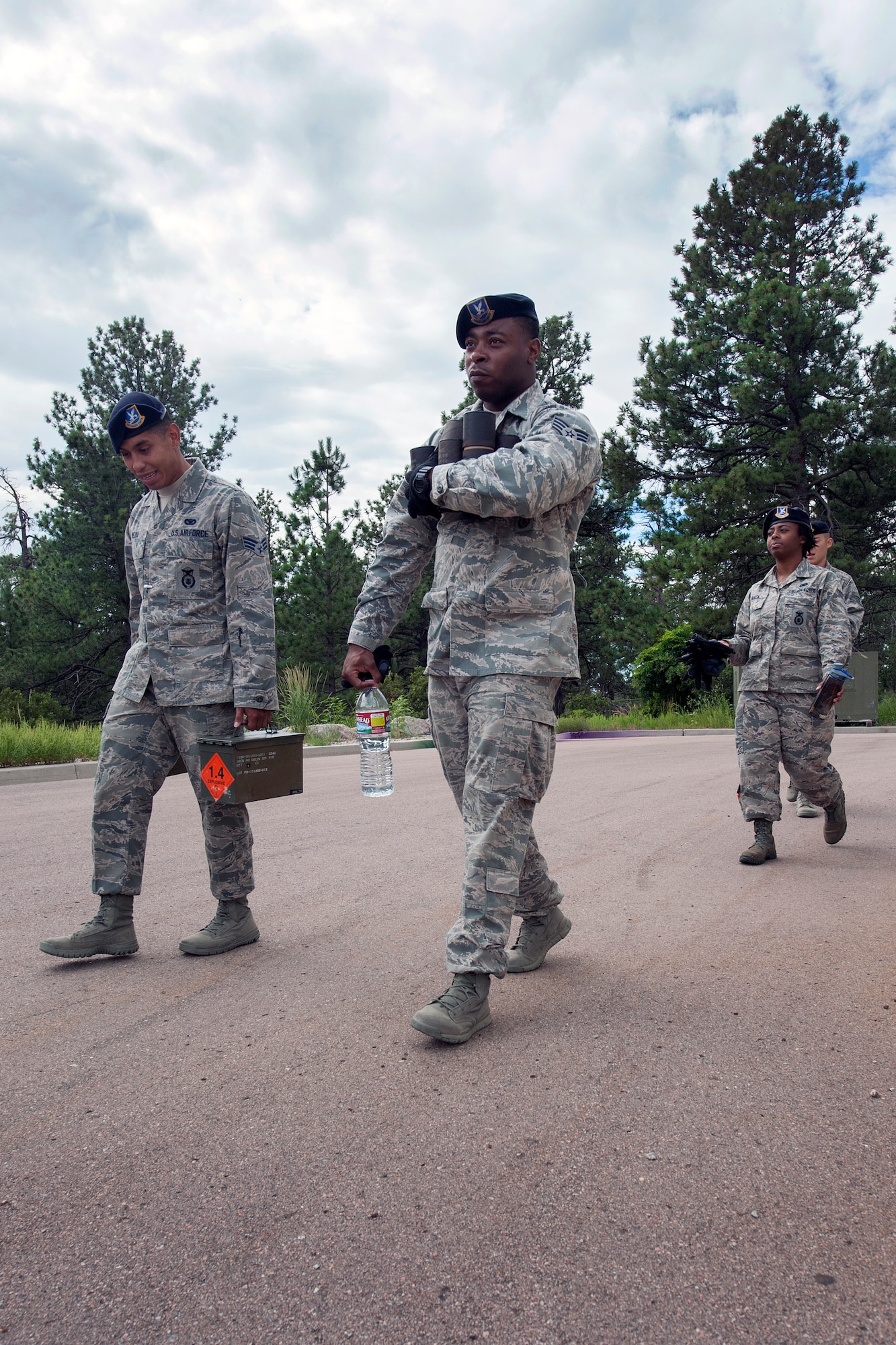 PETERSON AIR FORCE BASE, Colo. - Members of the 721st Security Forces Squadron, training section, carry expended M18 Smoke Grenades after hands-on training at Cheyenne Mountain Air Force Station on Aug. 3, 2015. The training provideed a realistic and safe training experience for personnel. (Photo by Craig Denton)
