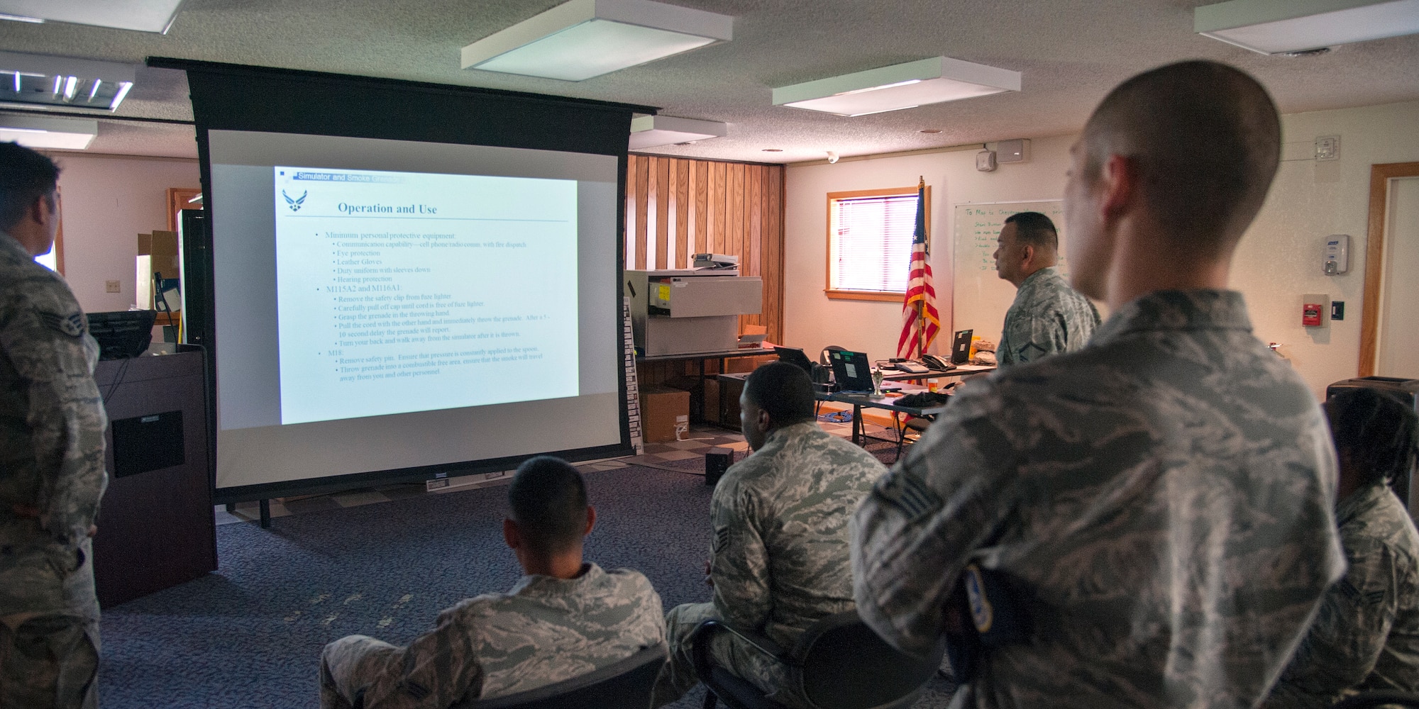 PETERSON AIR FORCE BASE, Colo. - Personnel from the 721st Security Forces Squadron training section at Cheyenne Mountain Air Force Station, review safety guidelines in preparation for M18 Smoke Grenade training on Aug. 3, 2015. The briefing provides personnel with instructions on how to properly operate and throw the grenade. The training is hands-on and allows each individual the opportunity to remove the safety pin, throw the grenade and watch the smoke discharged from the canister. (Photo by Craig Denton)
