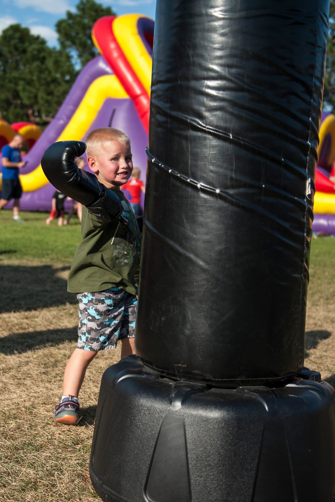 PETERSON AIR FORCE BASE, Colo. – Caleb Seamons, 4, tries kickboxing with gloves that are a little too big at the Family Festival and Concert on Aug. 7, 2015 at Patriot Park. The event was sponsored by local businesses and provided inflatable games, free food and other activities. It was open to all eligible users of Peterson Air Force Base and their families. (U.S. Air Force photo by Airman 1st Class Rose Gudex)