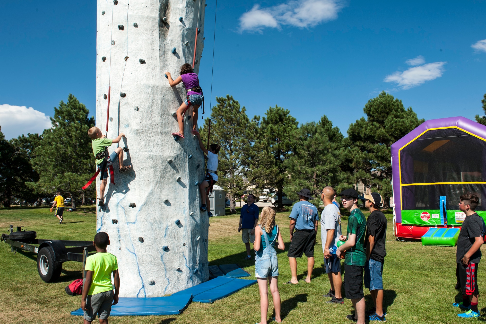 PETERSON AIR FORCE BASE, Colo. – Kids try to ring the buzzer at the top of the rock climbing wall at the annual Family Festival and Concert in the Park held at Patriot Park on Aug. 7, 2015. The event was held for all Peterson Airmen and their families and included free food, games and music from the Midnight Sun. (U.S. Air Force photo by Airman 1st Class Rose Gudex)