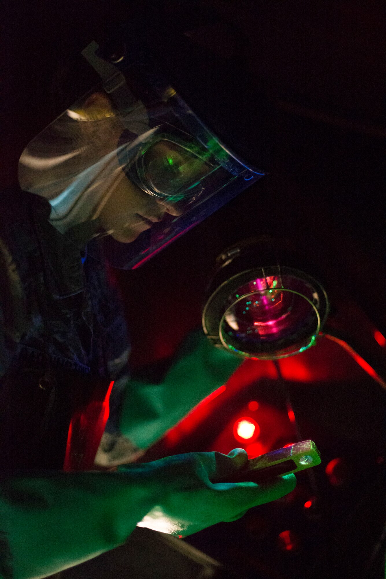 Airman 1st Class Danielle Harrington, 2nd Maintenance Squadron nondestructive inspection apprentice, uses a black light to find cracks on a part at Barksdale Air Force Base, La., July 21, 2015. The black light and magnetic particle solution combine to enable technicians to evaluate defects in aircraft and equipment parts. (U.S. Air Force photo/Senior Airman Jannelle Dickey)