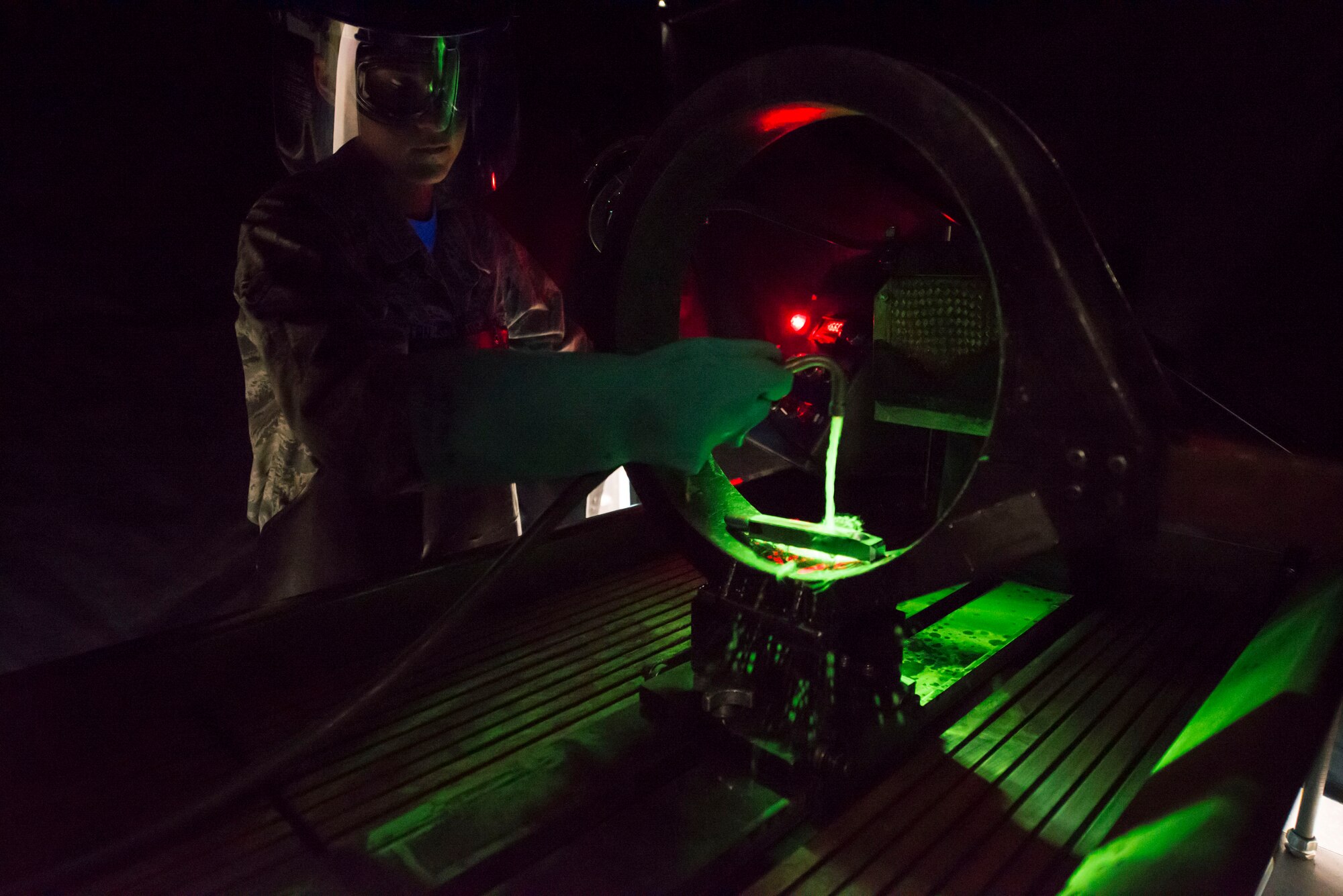 Airman 1st Class Danielle Harrington, 2nd Maintenance Squadron nondestructive inspection apprentice, sprays a magnetic particle solution on a part at Barksdale Air Force Base, La., July 21, 2015. The solution contains fluorescent particles that attach to the cracks in metals to help make the defect visible. (U.S. Air Force photo/Senior Airman Jannelle Dickey)