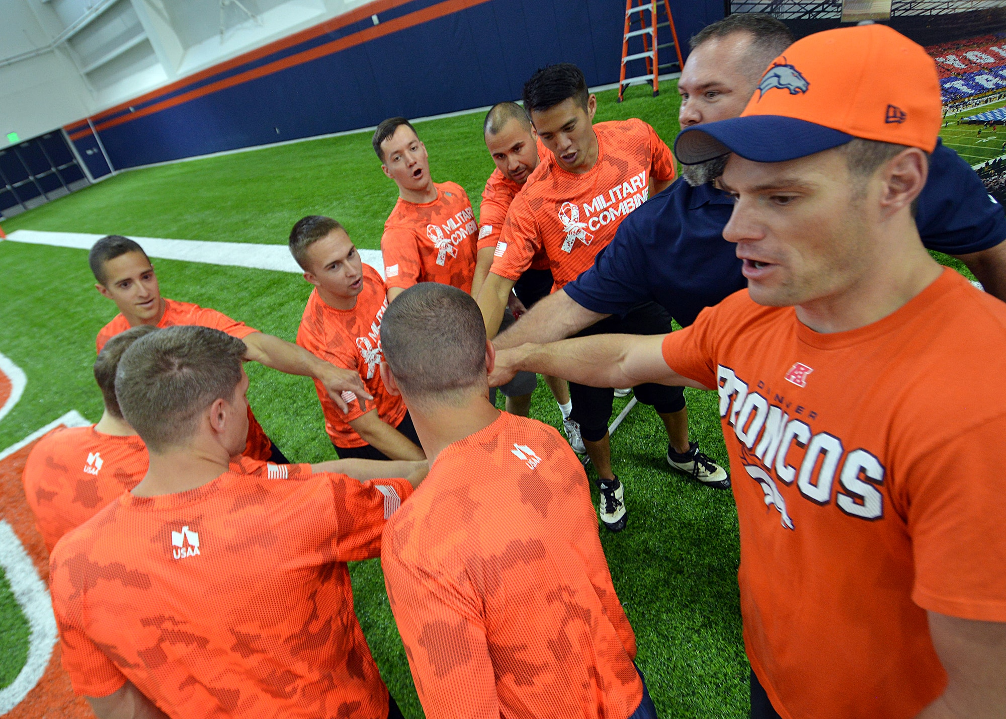 Service members come together for a morale boost with K.C. Jones, former center for the Denver Broncos, during the Denver Broncos Military Combine Friday, August 7, 2015, at the Dove Valley Fieldhouse in Englewood, Colorado. The coaches and sponsors of the event were so impressed with some of the participants of the military combine they put them on par with participants from the NFL combine. (U.S. Air Force photo/Staff Sgt. Debbie Lockhart)